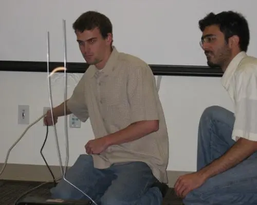 Two people lead a demonstration in front of a classroom.