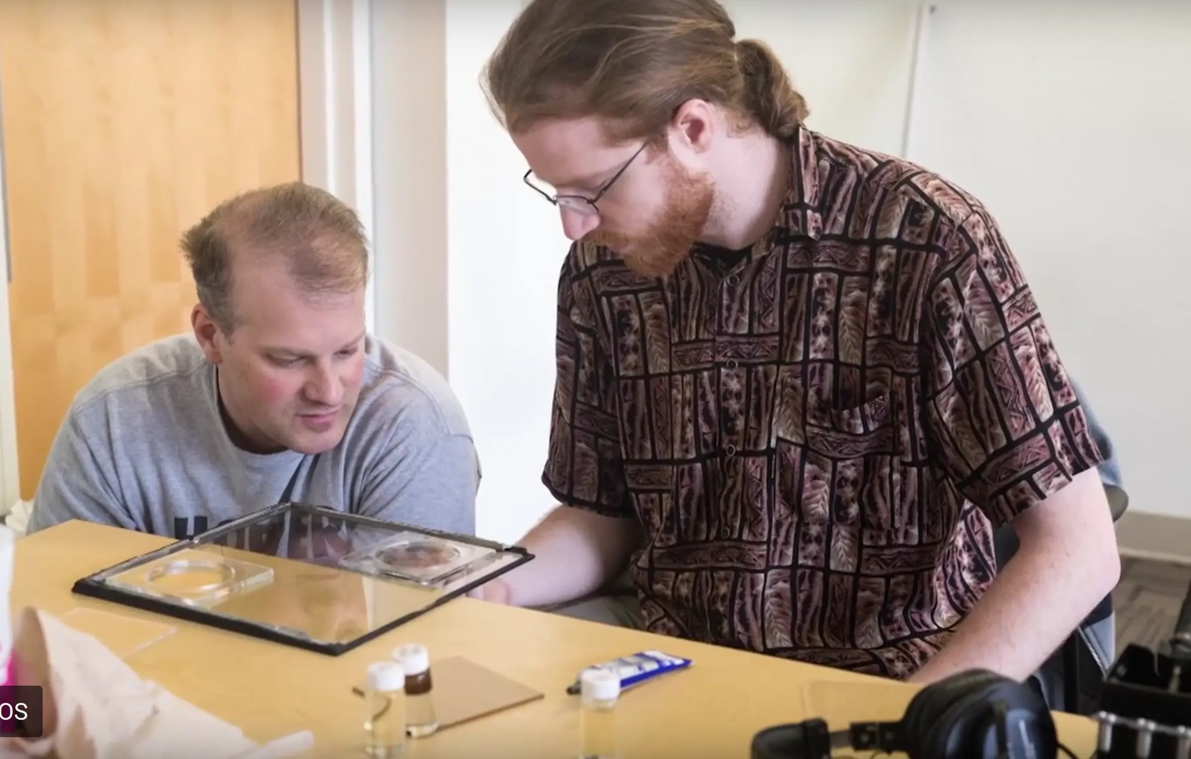 Graduate student Timoty Maguire working with student to build ferrofluid display.